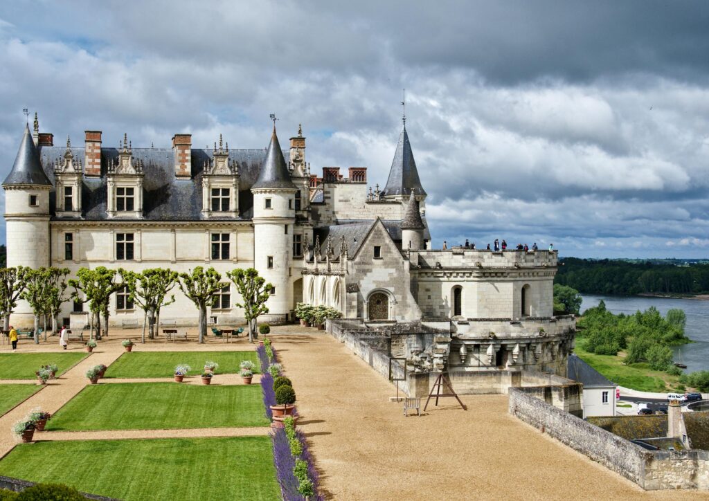 Majestic view of Château Royal d'Amboise and its gardens under a cloudy sky in France.