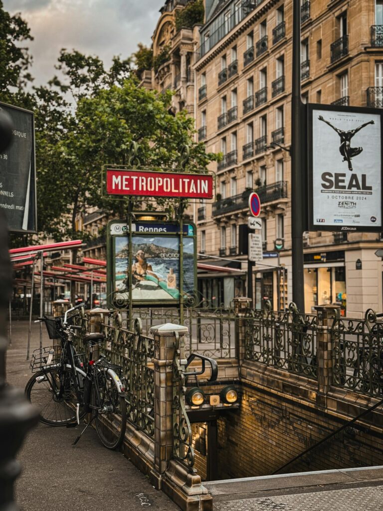 Paris metro entrance in an urban setting with historic architecture, bicycles, and street signs.