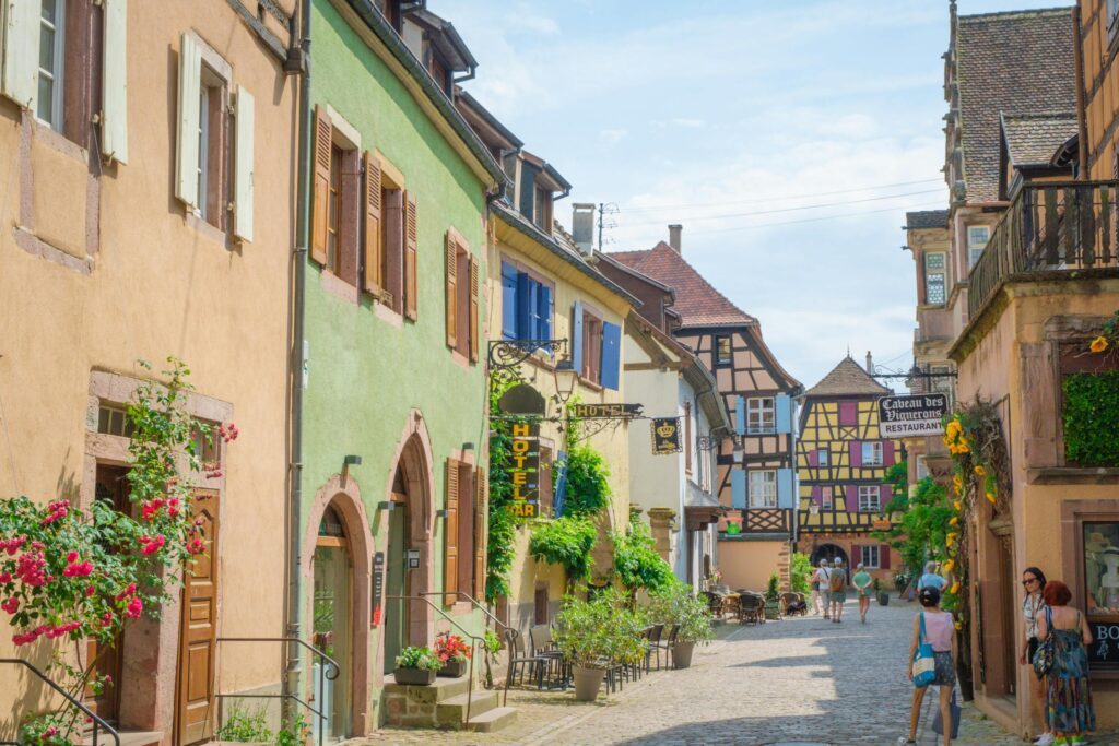 Picturesque street in Alsace, France showcasing vibrant facades and classic European architecture on a sunny day.