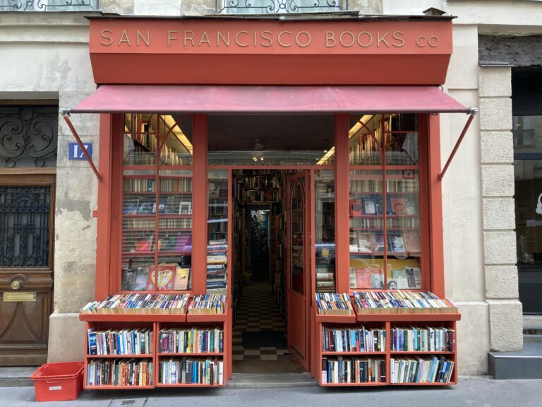Front view of San Francisco Books Co, featuring a vibrant red entrance with books on display.