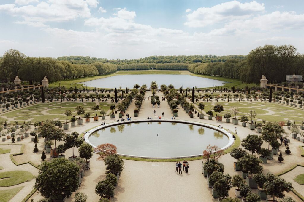 Stunning aerial view of Versailles gardens and ponds on a sunny day.