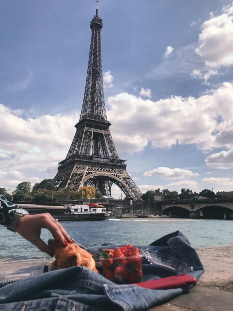 Enjoying a casual picnic by the Eiffel Tower in Paris on a sunny day.