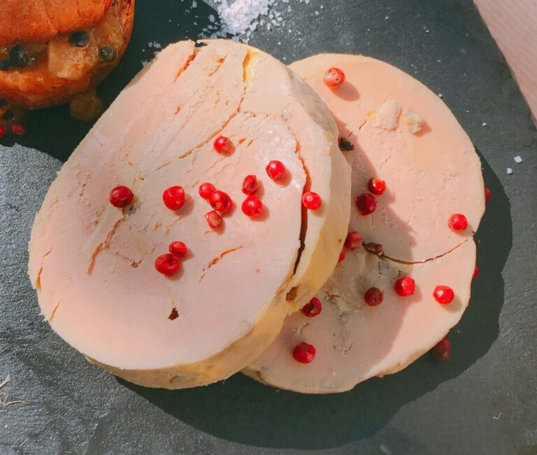 From above of delicious cut meatloaf served on black slate plate with appetizing crispy burger and decorated with pomegranate seeds