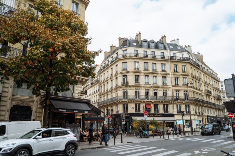 A picturesque view of a Paris street showcasing classic architecture and autumn vibes.