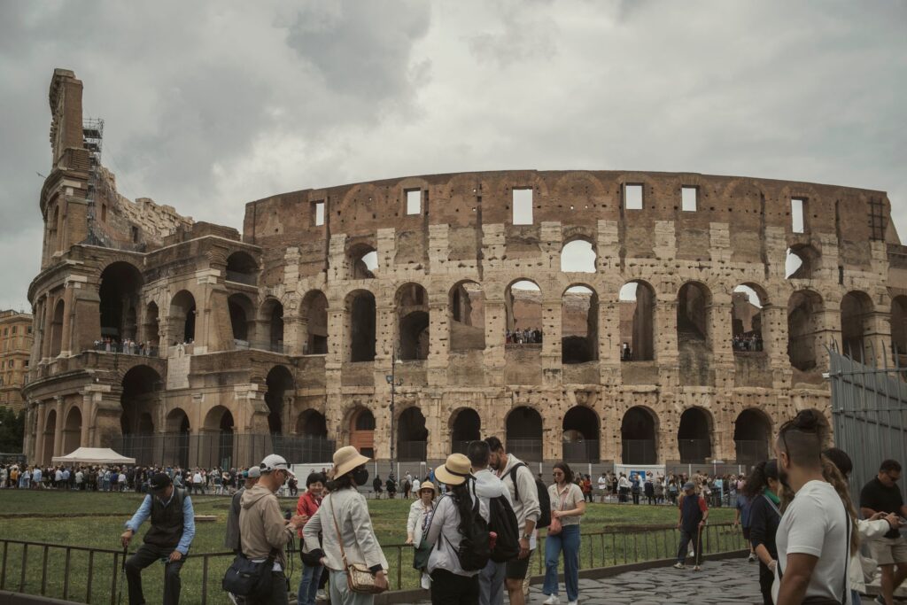 Tourists gather outside the historic Colosseum in Rome, capturing its majestic ancient architecture.